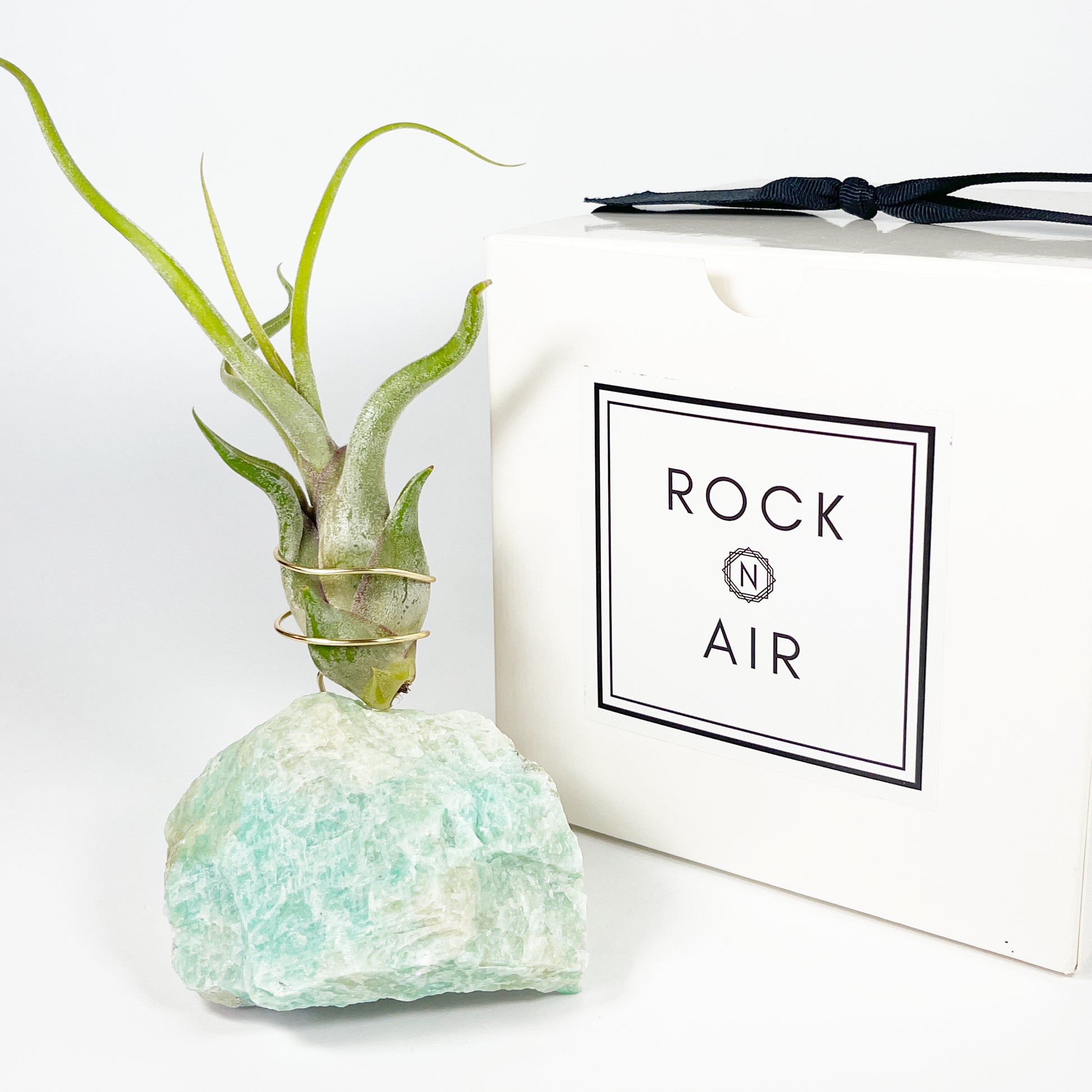 Decorative planter made from rock like Amazonite crystal sitting next to a 'Rock n Air' branded box on a white 
background